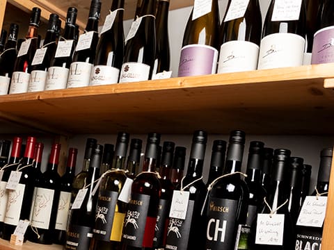 Weinregal im Ladengeschäft von Wein-Engelhardt in Nördlingen. Im unteren Bereich Rotweine und oben Rot- und Weißweine.