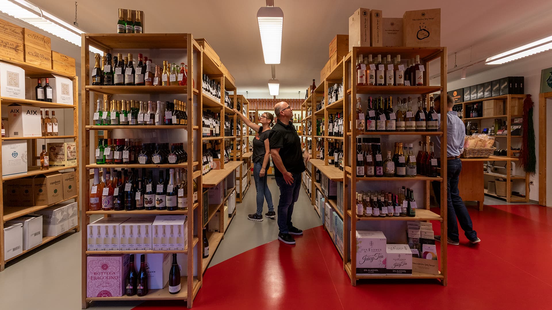 Blick in die Regale von Wein-Engelhardt, wo diverse Kund:innen ihren neuen Lieblingswein suchen.